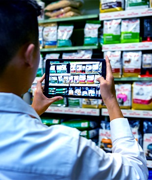 Merchandiser scanning dog food with a tablet